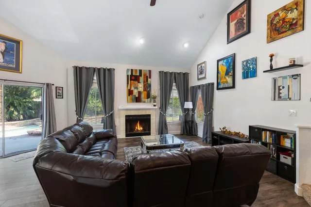a living room with furniture a flat screen tv and a fireplace