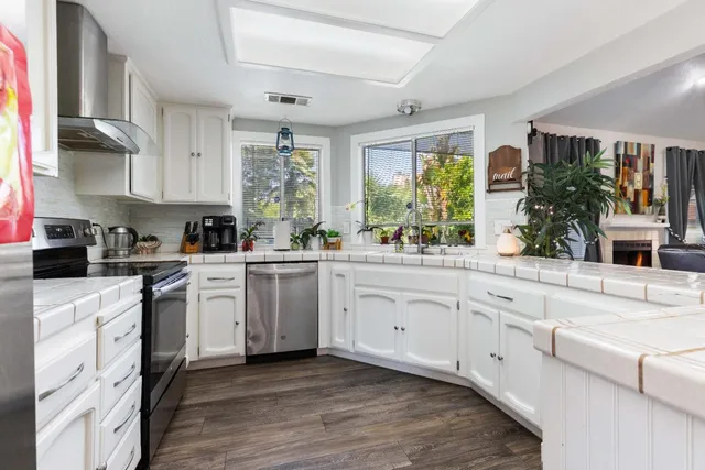 a kitchen with cabinets oven and a large window