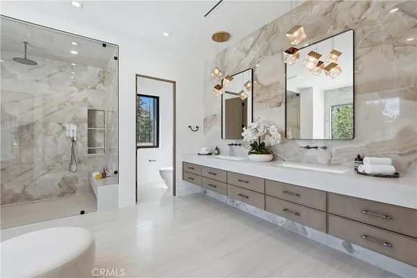 a bathroom with a double vanity sink toilet mirror and bathtub