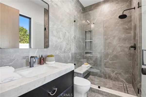 a bathroom with a sink a toilet and shower