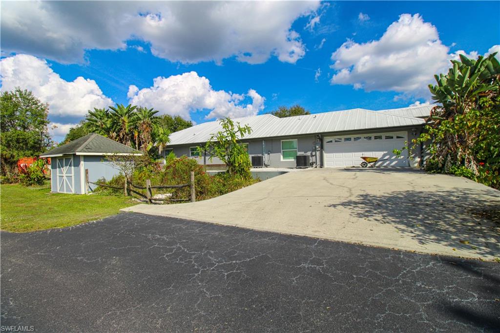 3935 70th Avenue Northeast Naples, FL 34120 - Photo 12 of 50 a view of a house with a yard and garage