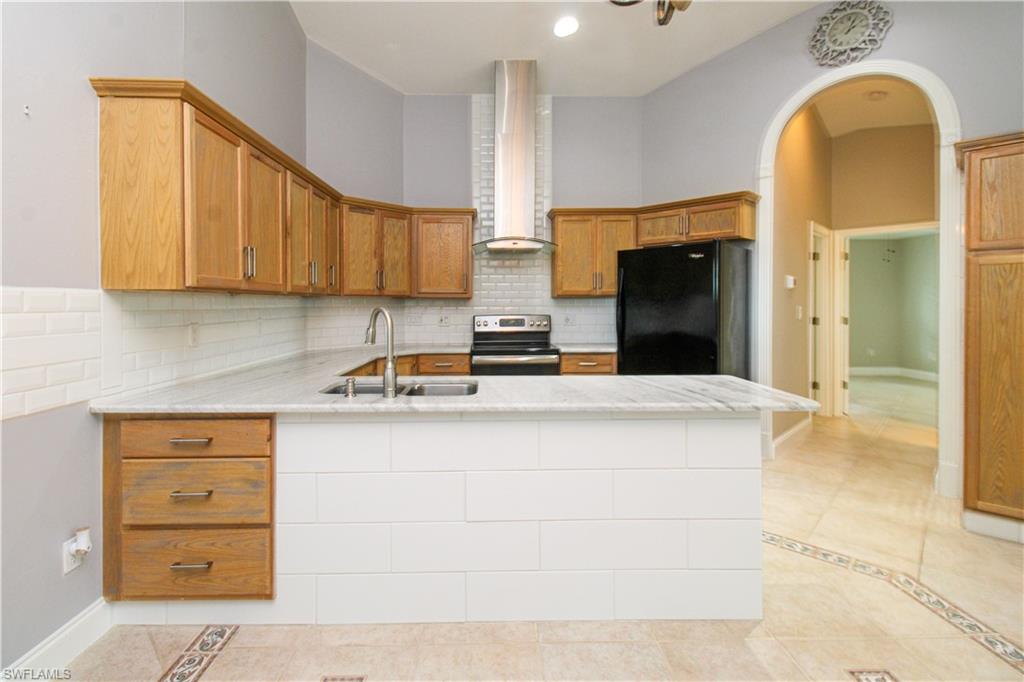 3935 70th Avenue Northeast Naples, FL 34120 - Photo 34 of 50 a kitchen with stainless steel appliances a stove refrigerator sink and cabinets