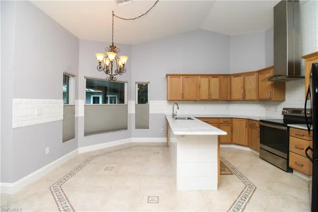 a kitchen with stainless steel appliances kitchen island granite countertop a refrigerator a stove top oven a sink and dishwasher