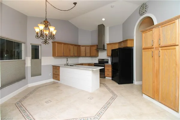 a kitchen with stainless steel appliances kitchen island granite countertop a refrigerator and a stove top oven