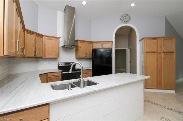 a kitchen with granite countertop a sink a stove and cabinets