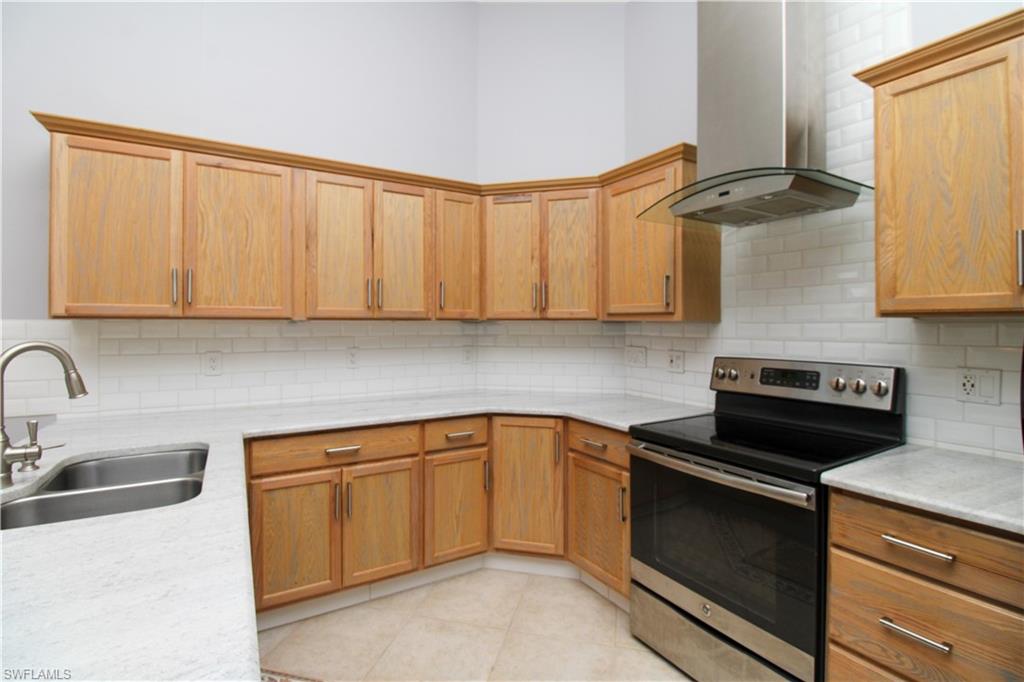 3935 70th Avenue Northeast Naples, FL 34120 - Photo 39 of 50 a kitchen with granite countertop a sink a stove and cabinets