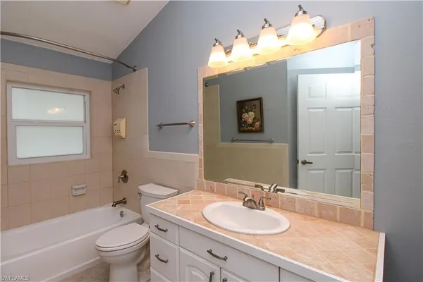a bathroom with a sink vanity granite and a mirror