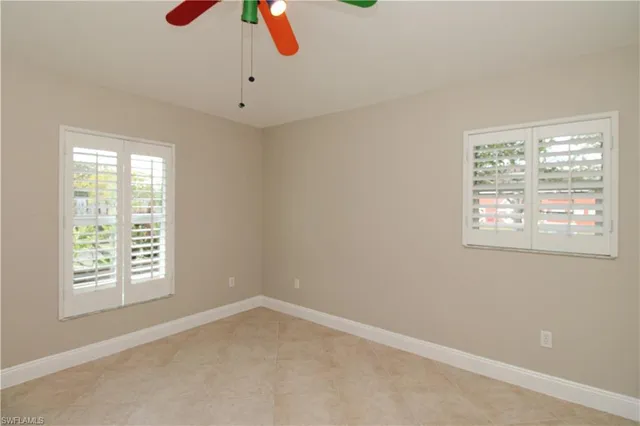 an empty room with closet and a ceiling fan