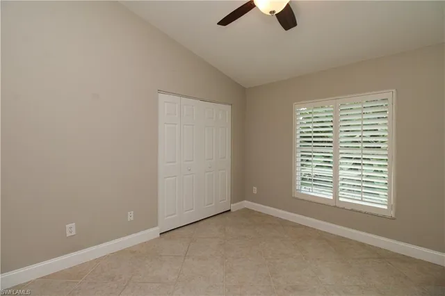 an empty room with a ceiling fan and carpet