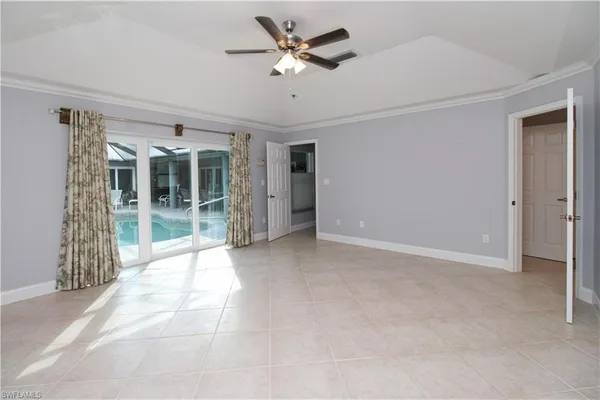 an empty room with a ceiling fan and a window