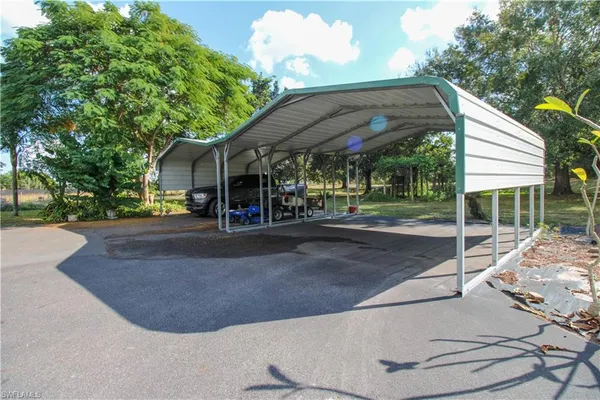 a view of a house with a yard and potted plants