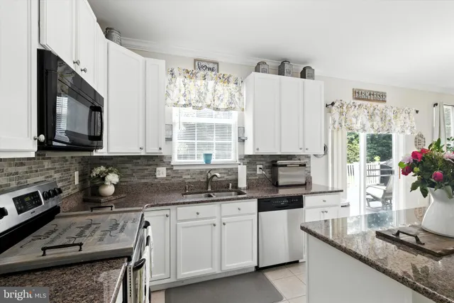 a kitchen with stainless steel appliances granite countertop a sink stove and cabinets