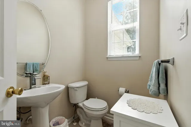 a white toilet sitting next to a bathroom sink and vanity
