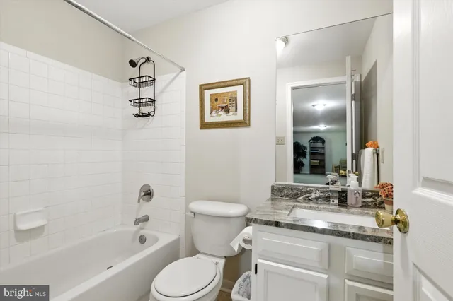 a bathroom with a granite countertop toilet a sink and a bathtub