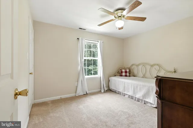a spacious bedroom with a bed and a ceiling fan