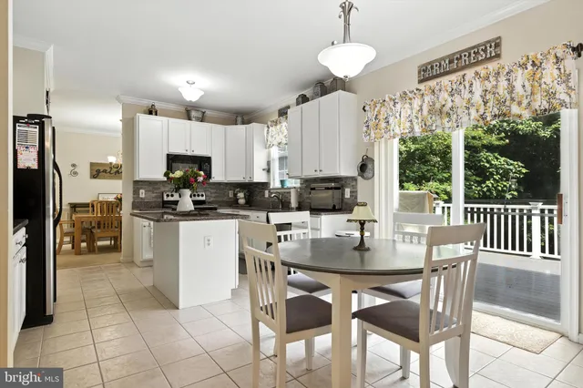 a kitchen with kitchen island granite countertop a table chairs microwave and cabinets