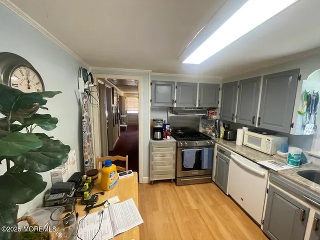 a kitchen with a refrigerator wooden floor and a sink