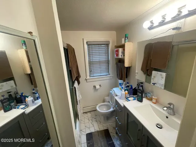 a bathroom with a sink a toilet and a mirror