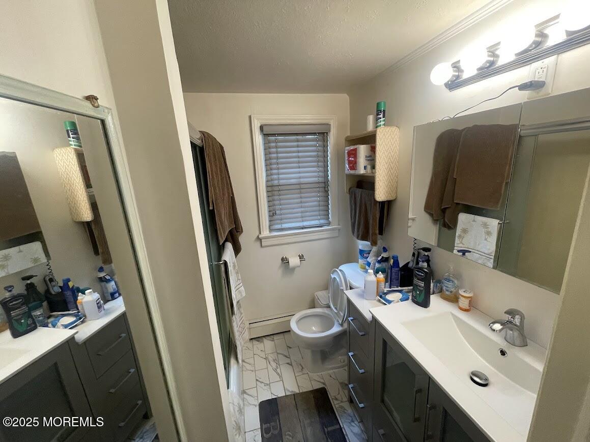 137 Inskip Avenue Ocean Grove, NJ 07756 - Photo 7 of 11 a bathroom with a sink a toilet and a mirror