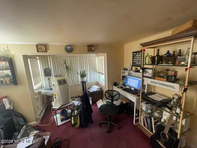 a view of a workspace with furniture and a window