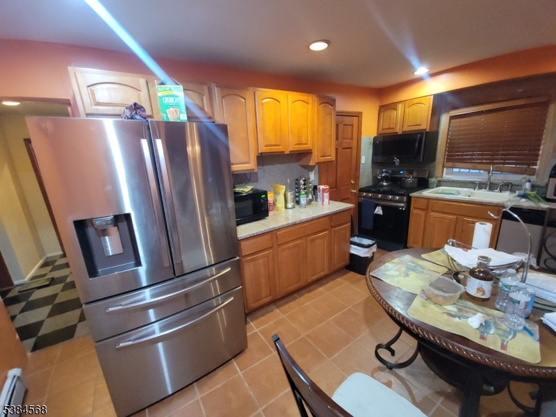 20 Greene Terrace Irvington, NJ 07111 - Photo 1 of 21 a kitchen with stainless steel appliances granite countertop a refrigerator a stove a sink a dining table and chairs with wooden floor
