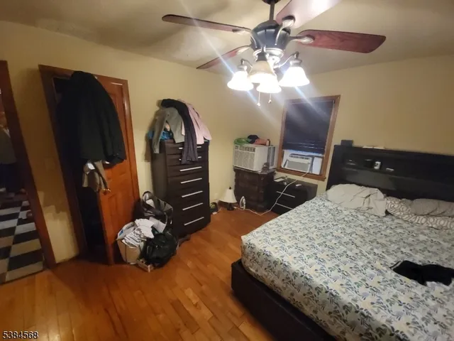 a bedroom with a bed dresser and wooden floor