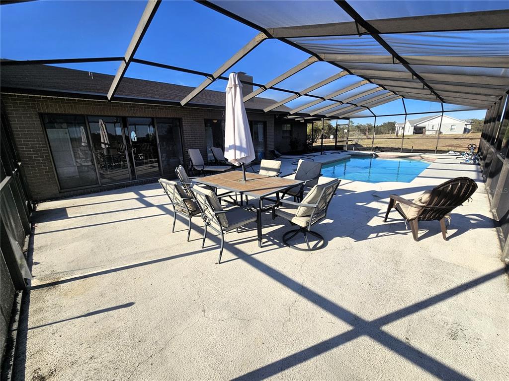 13308 Duck Lake Canal Road Dade City, FL 33525 - Photo 26 of 90 a view of a patio with table and chairs under an umbrella