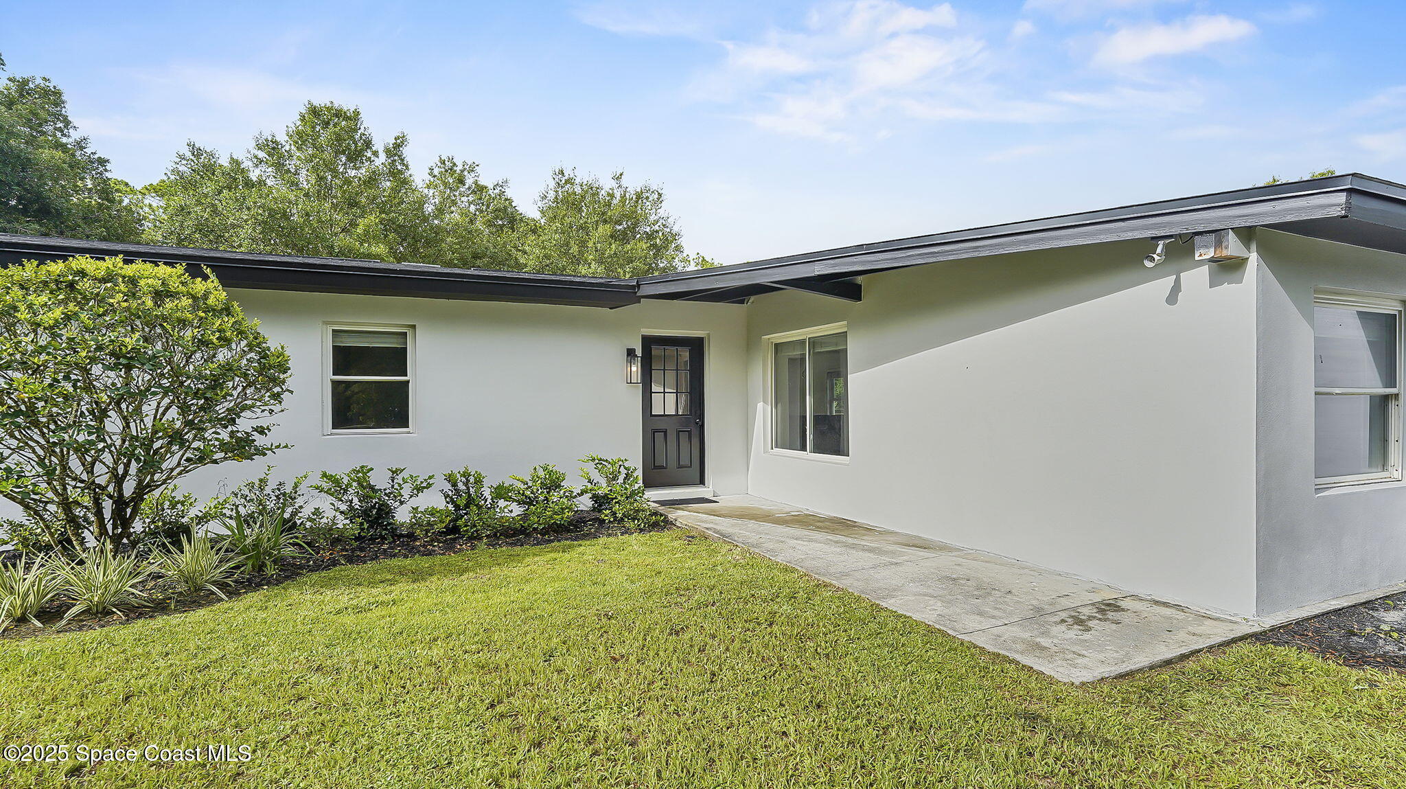 985 Hall Road Malabar, FL 32950 - Photo 3 of 39 a backyard of a house with table and chairs under an umbrella