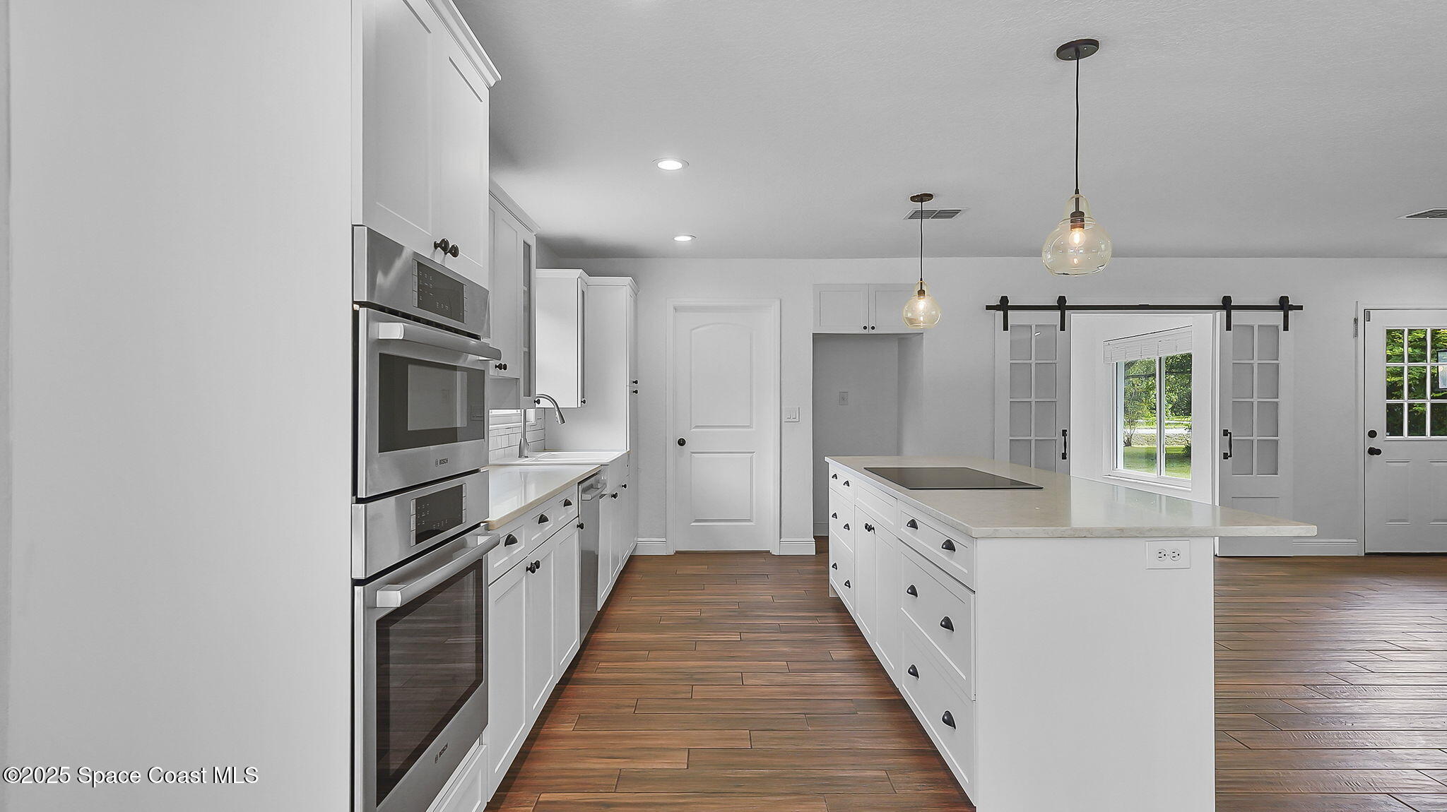985 Hall Road Malabar, FL 32950 - Photo 10 of 39 a large kitchen with stainless steel appliances kitchen island a cabinets and wooden floor