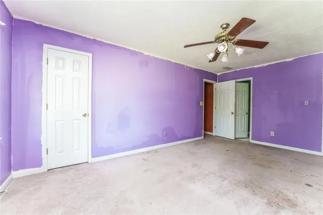 an empty room with a ceiling fan and a window