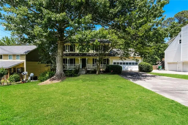 a front view of a house with a garden and trees
