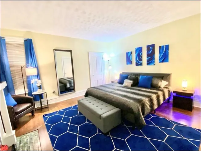 a bedroom with a bed and a mirror on dresser