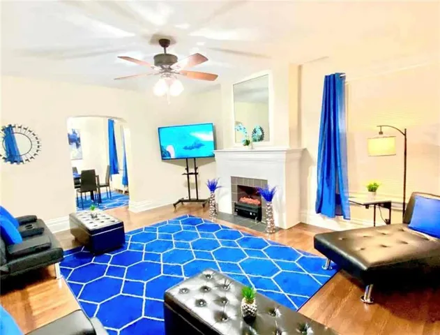 a living room with furniture a flat screen tv and a fireplace