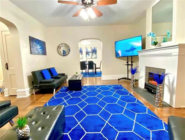 a living room with furniture a flat screen tv and a fireplace