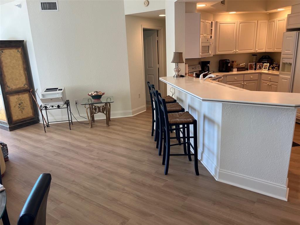1170 Gulf Boulevard, Unit 1203 Clearwater Beach, FL 33767 - Photo 14 of 34 a large white kitchen with a table and chairs
