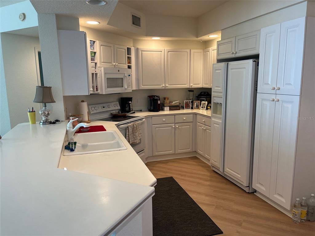 1170 Gulf Boulevard, Unit 1203 Clearwater Beach, FL 33767 - Photo 15 of 34 a kitchen with a sink a stove and refrigerator