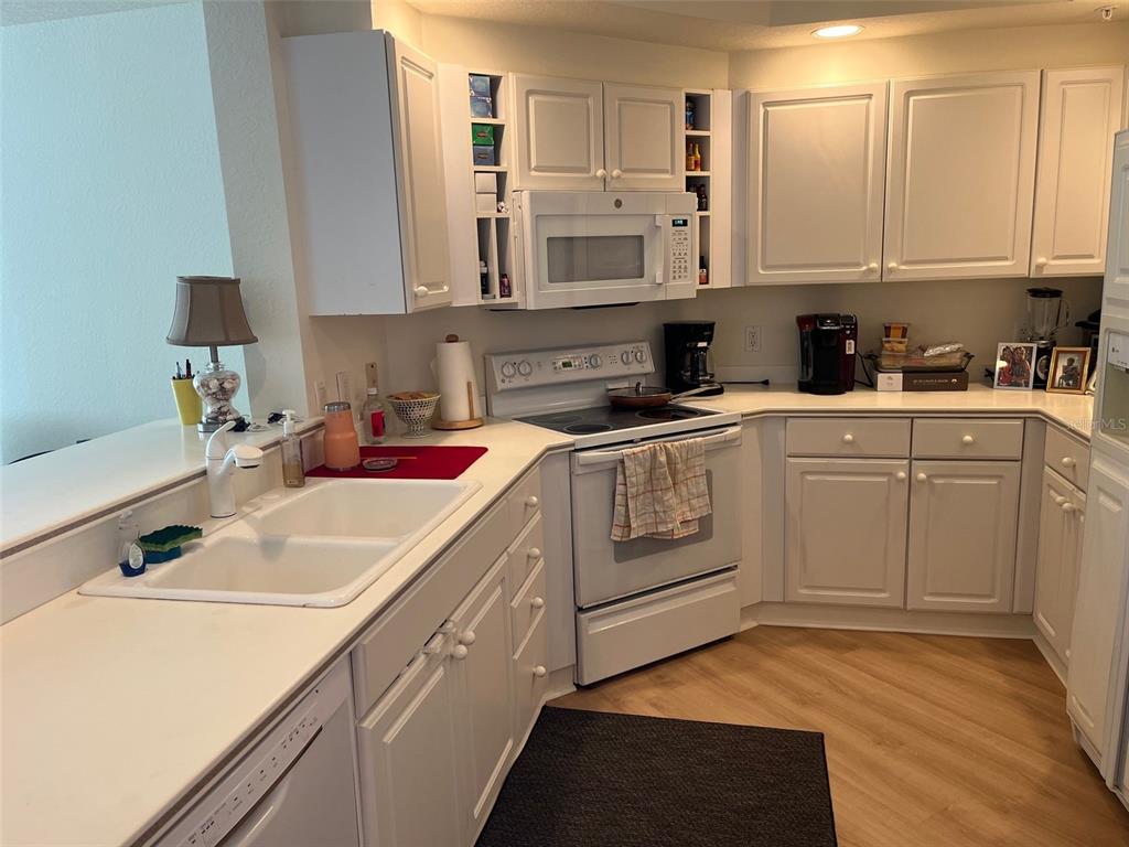 1170 Gulf Boulevard, Unit 1203 Clearwater Beach, FL 33767 - Photo 17 of 34 a kitchen with cabinets appliances a sink and a counter top space