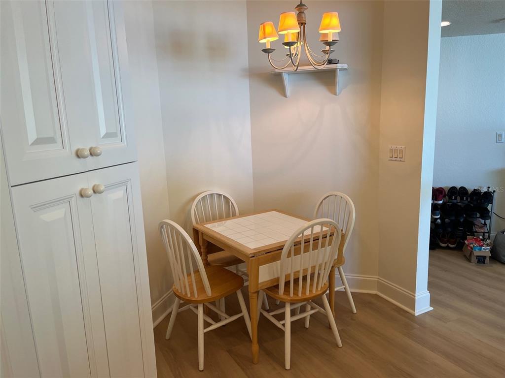 1170 Gulf Boulevard, Unit 1203 Clearwater Beach, FL 33767 - Photo 20 of 34 a view of a dining room with furniture and wooden floor