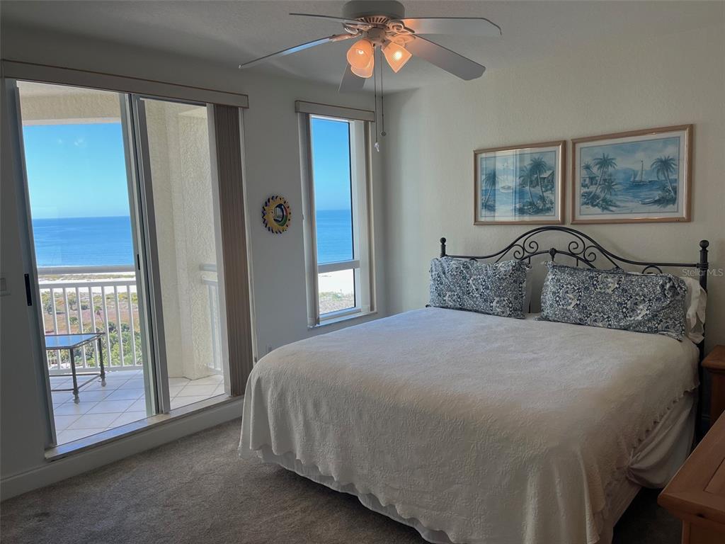 1170 Gulf Boulevard, Unit 1203 Clearwater Beach, FL 33767 - Photo 28 of 34 a bedroom with a bed and a chandelier