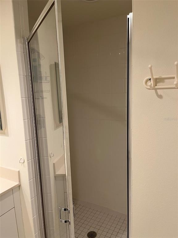 1170 Gulf Boulevard, Unit 1203 Clearwater Beach, FL 33767 - Photo 34 of 34 a bathroom with a glass door shower and vanity
