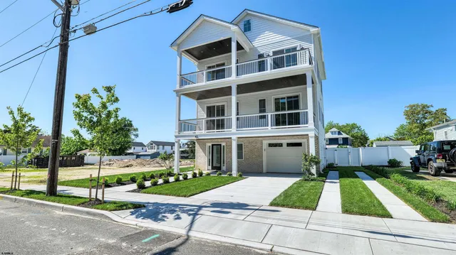 a view of a livingroom with wooden floor a ceiling fan and windows