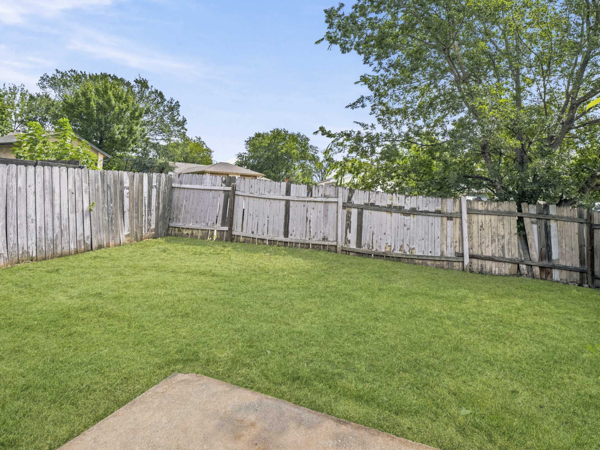 2401 Burleson Road Austin, TX 78741 - Photo 10 of 25 A generous lawn area is enclosed by privacy fencing, perfect for outdoor activities.