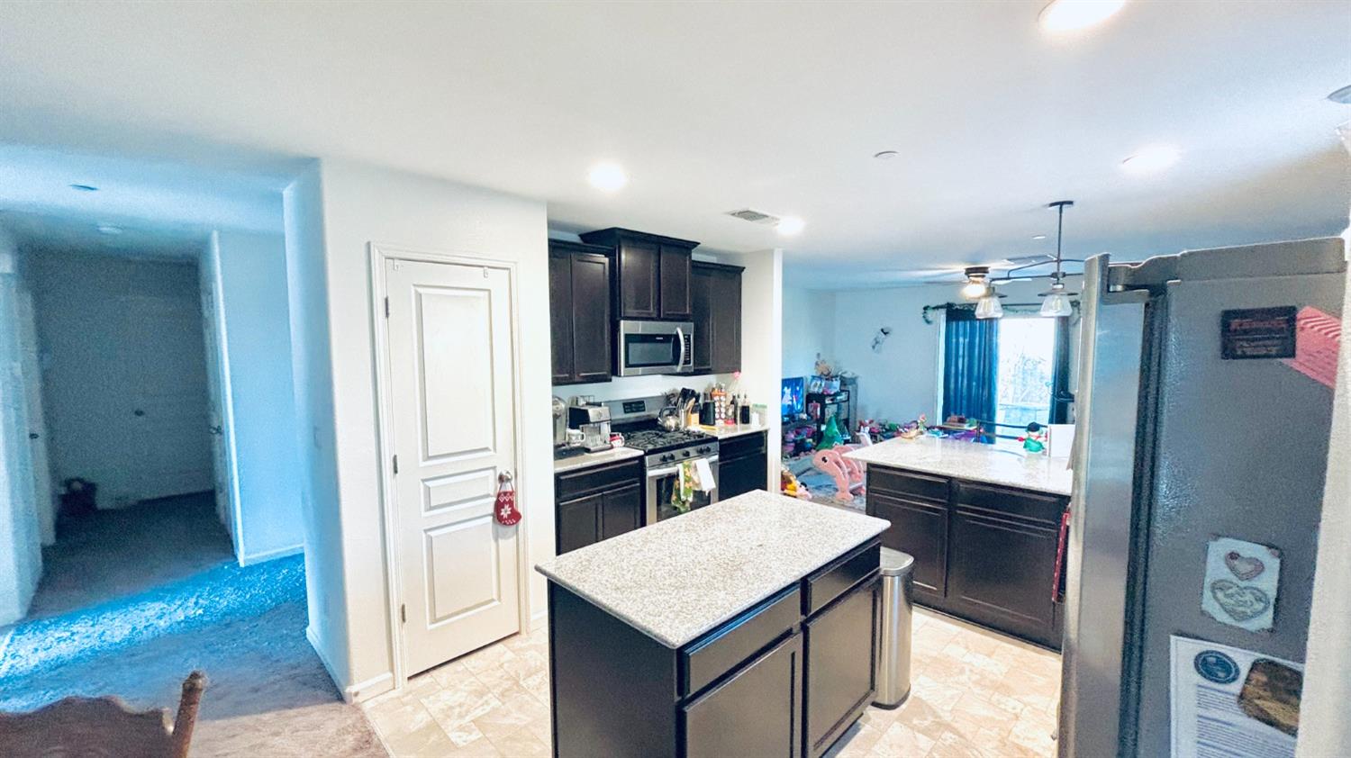 356 Solano Street Madera, CA 93638 - Photo 3 of 15 a kitchen with a refrigerator a sink dishwasher with a dining table and chairs