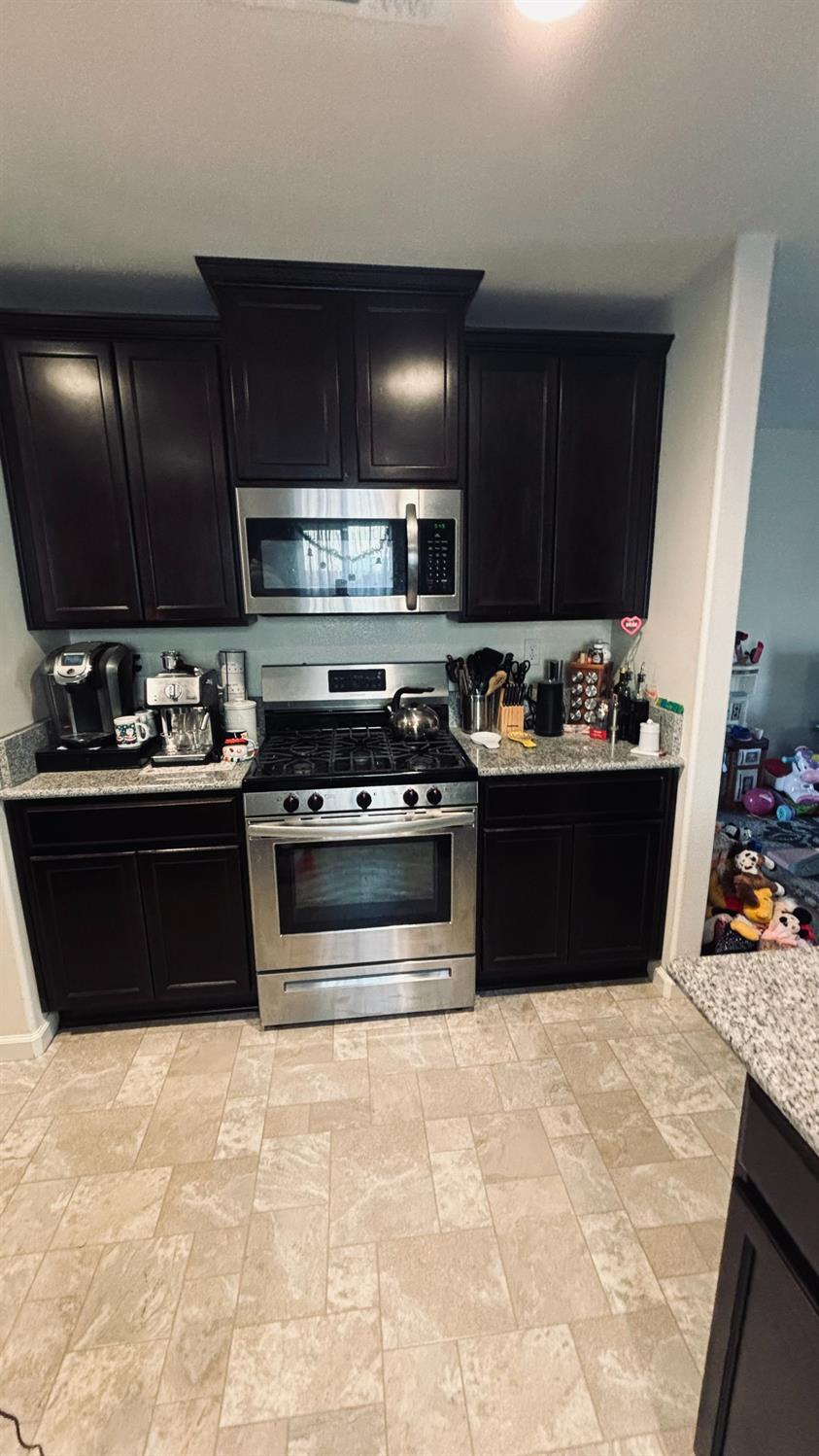 356 Solano Street Madera, CA 93638 - Photo 5 of 15 a kitchen with a stove and a refrigerator