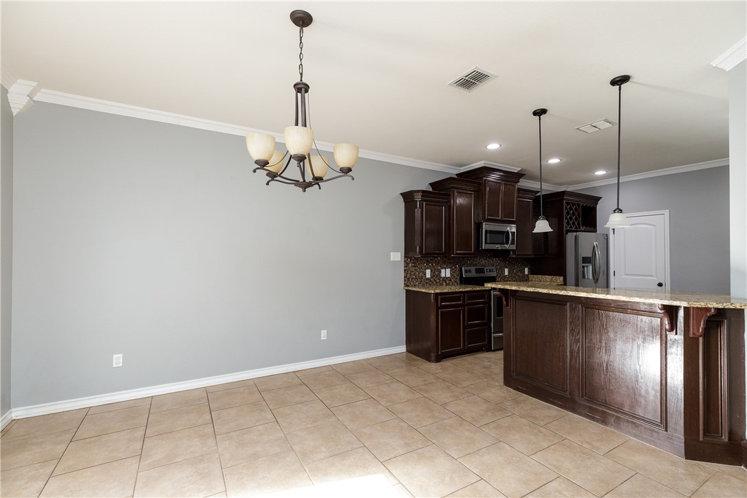8314 Excalibur Road Corpus Christi, TX 78414 - Photo 8 of 26 a kitchen with stainless steel appliances granite countertop a refrigerator and a stove top oven
