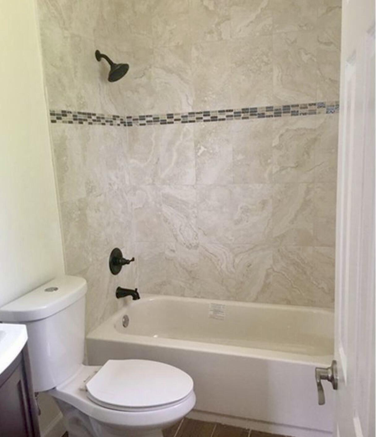 2811 Northwest 8th Street Pompano Beach, FL 33069 - Photo 6 of 7 a white toilet and tub sitting next to a bathroom sink