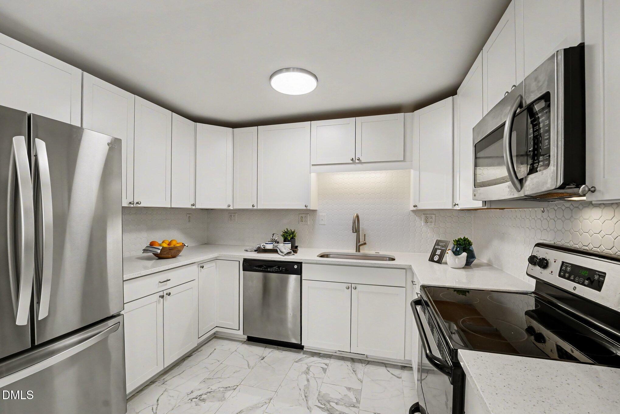 2125 Cheek Road Durham, NC 27704 - Photo 12 of 24 a kitchen with stainless steel appliances a sink stove refrigerator and cabinets