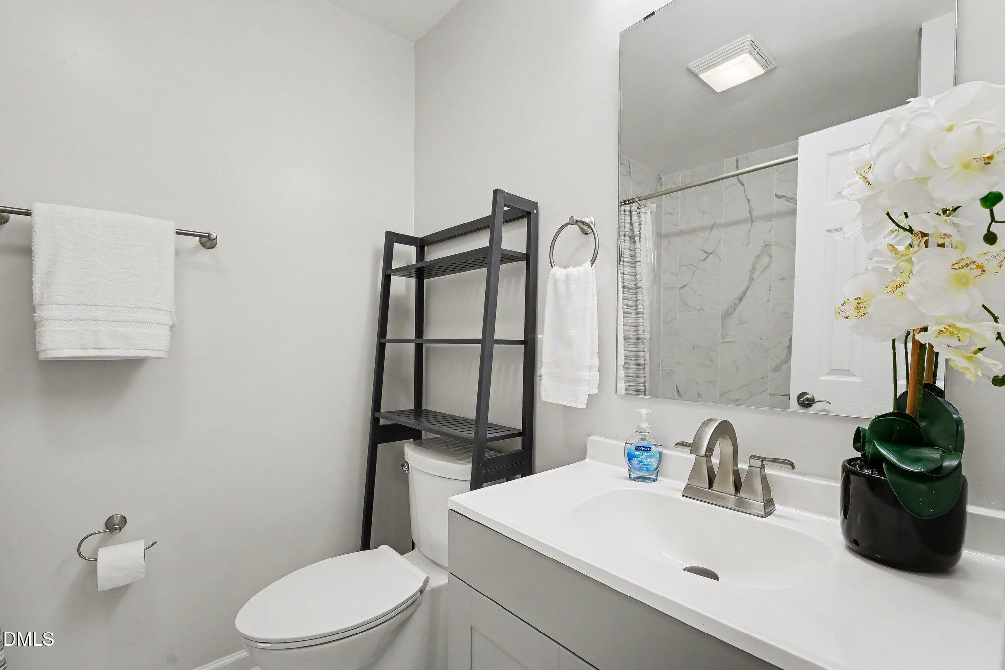 2125 Cheek Road Durham, NC 27704 - Photo 16 of 24 a bathroom with a sink a toilet and shower curtain