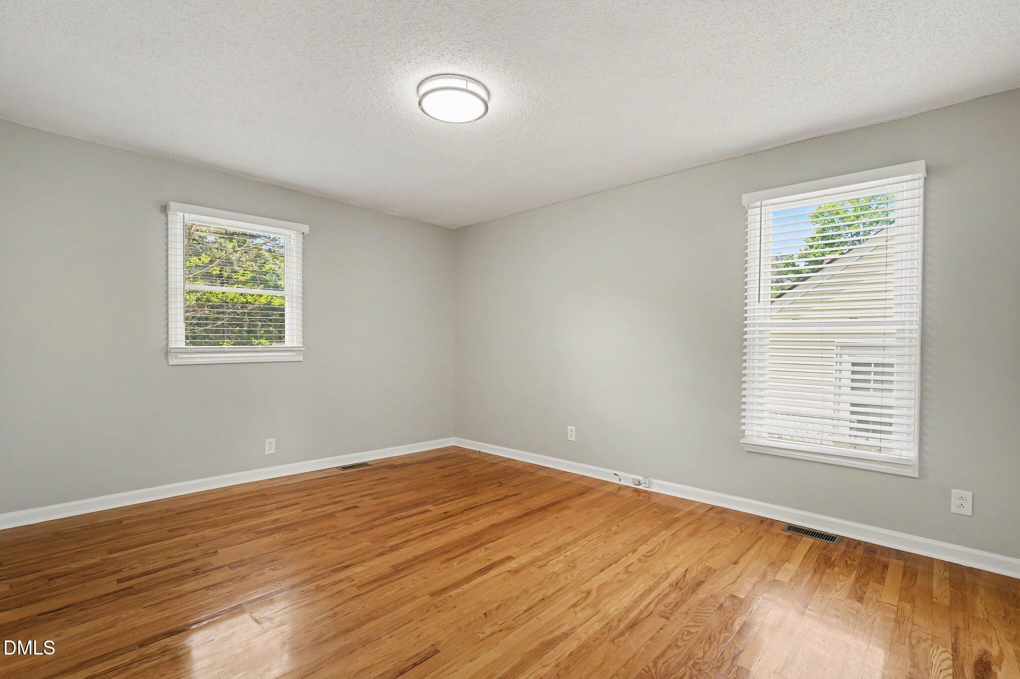2125 Cheek Road Durham, NC 27704 - Photo 18 of 24 a view of an empty room with wooden floor and a window