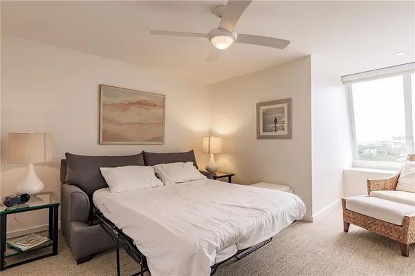 a bedroom with a bed and a large window